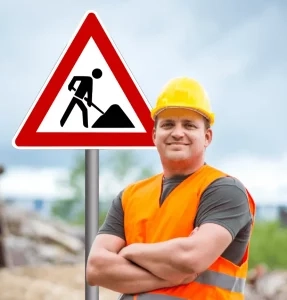 Mitarbeiter mit Warnweste vor Baustellenschild als symbolisches Bild für eine RSA 21 Online Schulung zur Baustellensicherung.